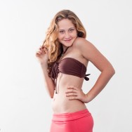 Rachael in a brown bandeau and pink skirt